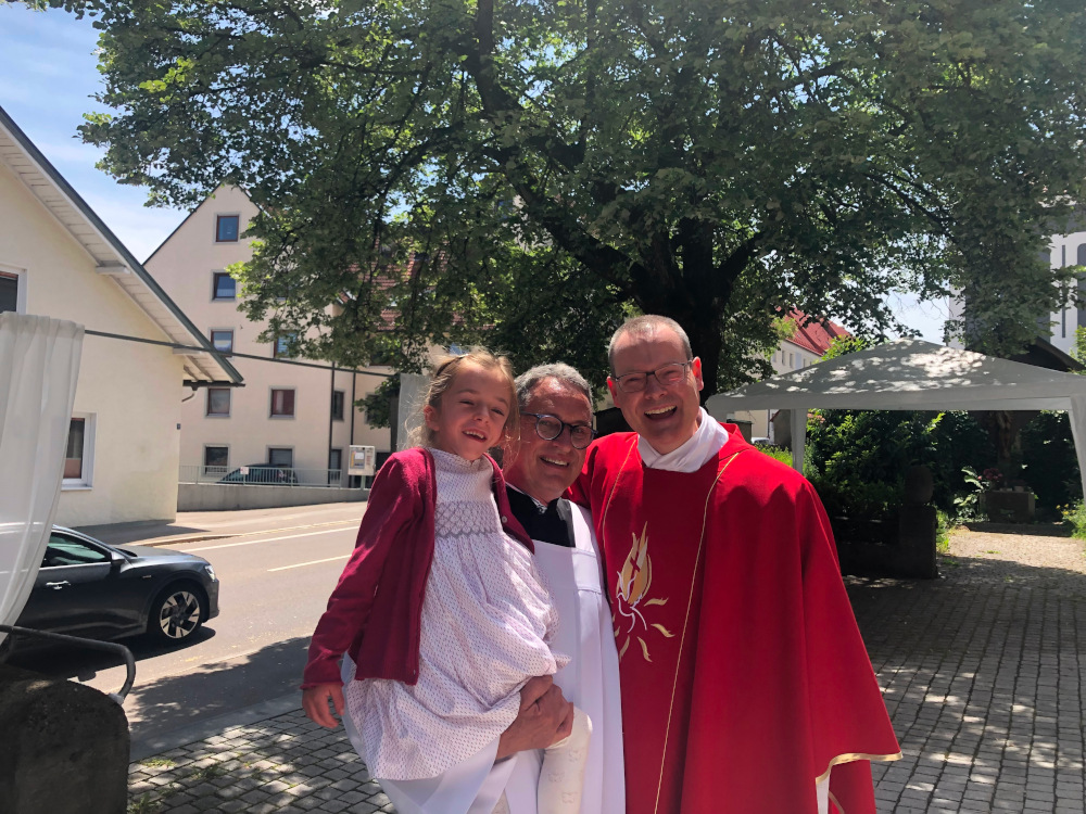Zwei Priester mit einem Kind